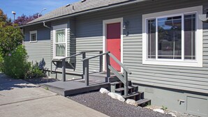 A two-story house with a red door, a small front porch, and a visible chimney. - Downtown Friday Harbor! Adults Only (CCS#2) (Friday Harbor)