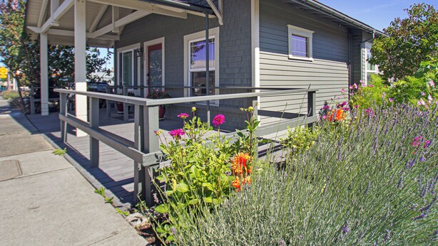 A two-story house with a covered porch and a garden with various flowers. - Downtown Friday Harbor! Adults Only (CCS#2) (Friday Harbor)