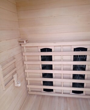 A room with a wooden slatted wall and a glass on a shelf. - TEREZA PALACE (Pavel Banya)