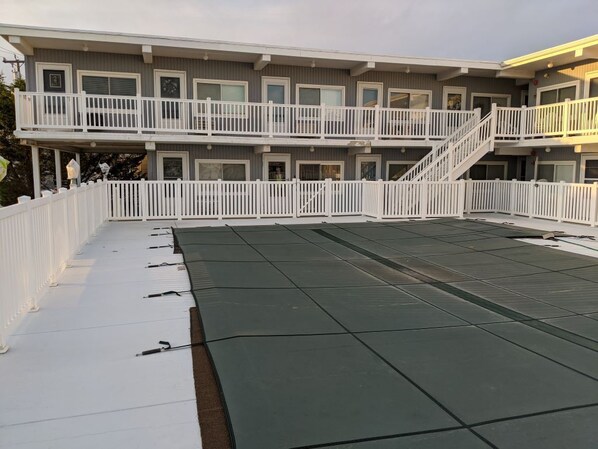 Un hotel de varios pisos con balcones y una terraza en la azotea.