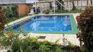 Una piscina rodeada de exuberante vegetación y palmeras.
