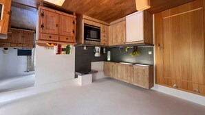Eine moderne Küche mit Holzschränken, einer schwarzen Arbeitsplatte und einer Edelstahl-Dunstabzugshaube.