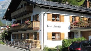 Ein zweistöckiges Gebäude mit hölzernen Balkonen und Blumenkästen, mit der Aufschrift 'Haus Carolina'.