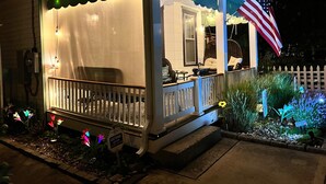 Une maison avec une véranda, un espace couvert doté d’une balustrade et un drapeau américain.