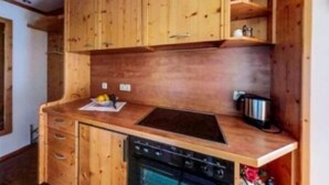 A wooden kitchen with cabinets, a stove, and a sink. - Ferienwohnung , Terr., Küche, 2 Schlaf- u. 1 Wohn-/schlafz., max 4 P (Ruhpolding)