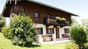 A wooden chalet with a balcony, a bench, and a small garden area. - Ferienwohnung , Terr., Küche, 2 Schlaf- u. 1 Wohn-/schlafz., max 4 P (Ruhpolding)