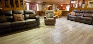 A cozy living room with a brown leather sofa, a matching armchair, and a wooden dining table with chairs. - Walk 2 River & Entertainment & Hippie Chicks, River Road, Heart of Concan! (Concan)