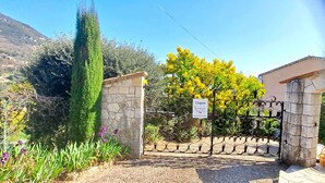 A gated entrance with a stone wall and a sign indicating 'L'Eguienne'.