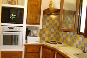 A kitchen with a microwave, oven, toaster, and a checkered backsplash. - BEAUTIFUL ACCOMODATION ON AGRITOURISME NEAR NICE ANTIBES CANNES  (Le Bar-sur-Loup)