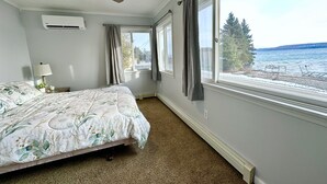 Ein Schlafzimmer mit Bett, Deckenventilator, Klimaanlage und Seeblick.