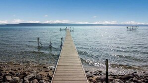 Eine Holzstege, der sich in ruhiges Wasser erstreckt, umgeben von Felsen.