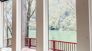 A room with large windows overlooking a river, a red railing, and a sign that reads "THIS IS OUR HAPPY PLACE". - On Beautiful White River, Minutes from Sylamore Creek and Blanchard Springs (Mountain View)