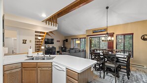 A spacious kitchen with a large island, wooden cabinets, and a built-in dishwasher.
