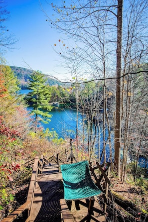 A wooden deck with a green hammock, overlooking a lake surrounded by trees. - Black Bear Lodge at gorgeous Lake Jocassee (Salem)