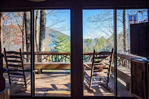A room with a wooden deck, a bench, and a view of a forested area. - Black Bear Lodge at gorgeous Lake Jocassee (Salem)