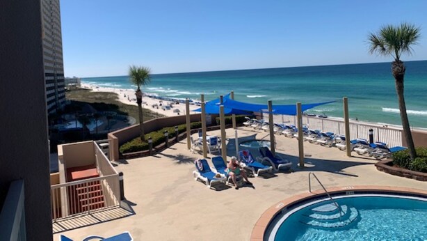 A pool area with lounge chairs and a view of the beach and ocean. - Beach Front Condo-Amazing Ocean Views-Direct Access- Two Awesome Pools/Hot Tubs (Panama City)