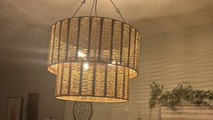A room with a hanging woven light fixture, a dining table, chairs, and wall decorations including a framed quote. - Beach Front Condo-Amazing Ocean Views-Direct Access- Two Awesome Pools/Hot Tubs (Panama City)