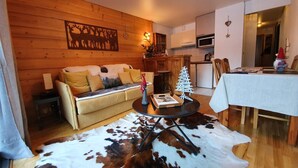 Un salon chaleureux avec un mur en bois, un canapé, une table basse et un tapis en peau de vache.