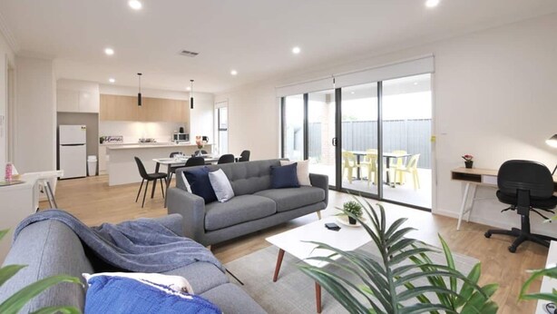 A modern apartment with a living room, kitchen, and balcony.
