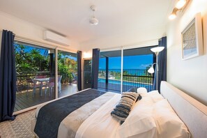 A hotel room with a bed, a view of a swimming pool, and a balcony. - 49 On Airlie - Airlie Beach (Airlie Beach)