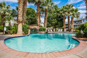 A swimming pool surrounded by palm trees and a brick border. - Dreamy Summer Stay-Cozy Condo for Couples (St George)
