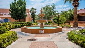 A fountain in a courtyard surrounded by greenery and buildings. - Dreamy Summer Stay-Cozy Condo for Couples (St George)