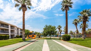 A park with shuffleboard courts, palm trees, and a playground. - Dreamy Summer Stay-Cozy Condo for Couples (St George)