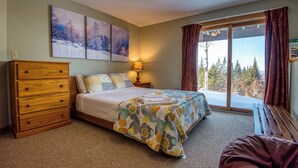 A bedroom with a bed, wooden dresser, and a window with curtains. - Rock Pond Condo 75 | Beautiful end unit at Saddleback (Sandy River Plantation)