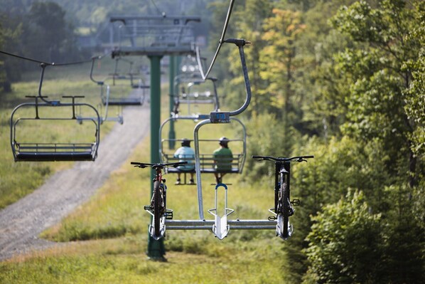 A ski lift with a chair in the foreground and another in the background.