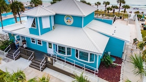A turquoise building with a beach view, a sign reading "Coconut Highlands Beach Resort," and a staircase leading to the entrance. - ❃ Walkable to Food & Fun ❃ Beach-Front Pool ❃ Canal-Side Home ❃ No Pet Fee (Panama City Beach)