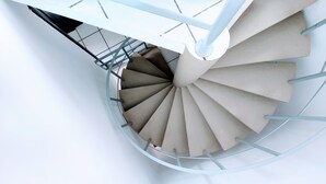 A spiral staircase with a white interior and metal railings. - Triplex in Caiobá-Matinhos-Pr 200 m from the sea (Matinhos)