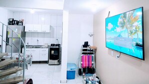 A modern kitchen with white cabinets, a stainless steel refrigerator, and a dining area with a checkered tablecloth. - Triplex in Caiobá-Matinhos-Pr 200 m from the sea (Matinhos)