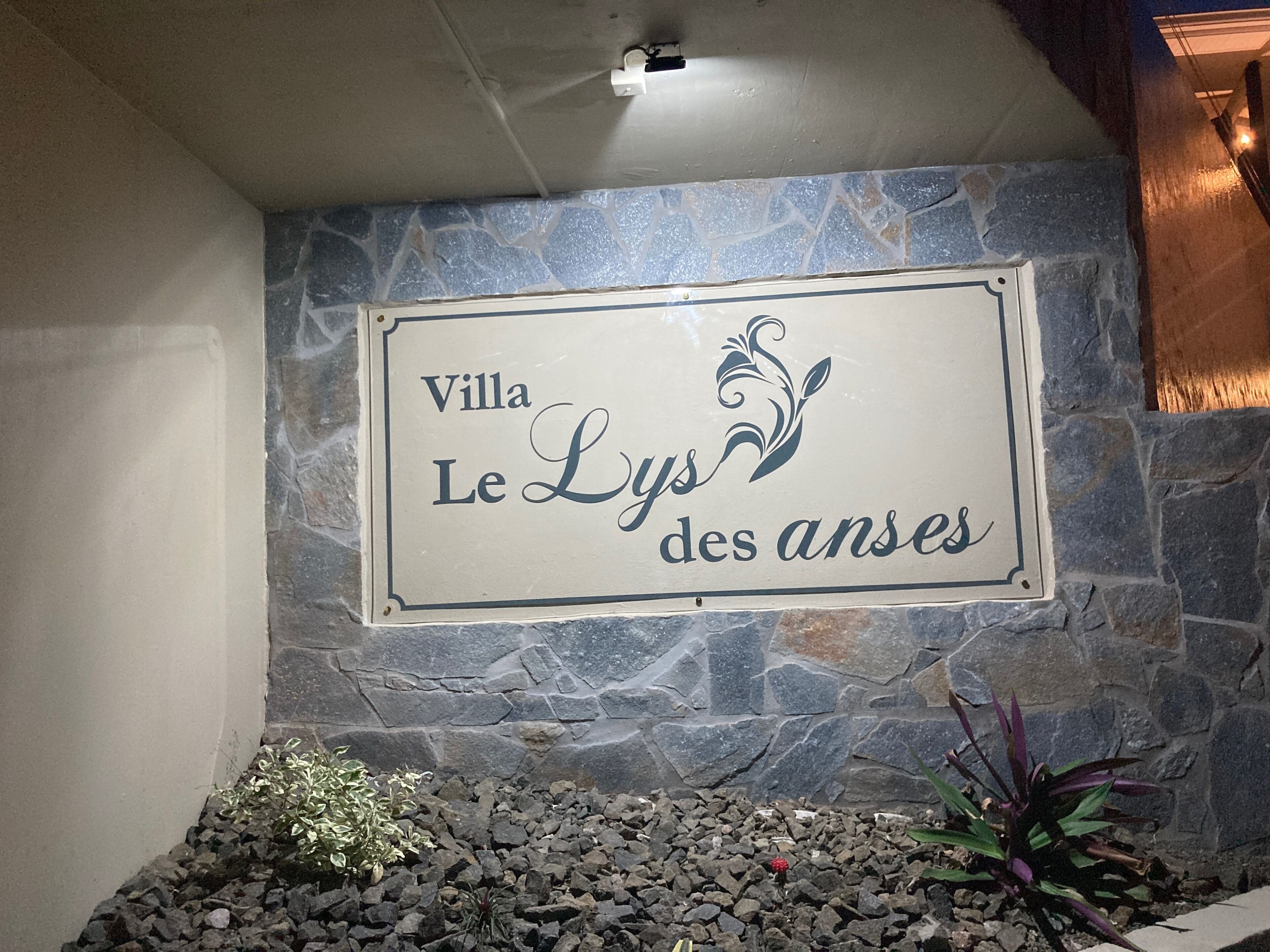Une plaque sur un mur de pierre portant l’inscription : « Villa Le Lys des anses ».
