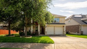 A residential house with a garage, a well-maintained lawn, and a tree in the front yard. - ★ Luxurious Two-Story Home ★ Near La Cantera/Rim (San Antonio)