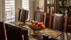 A dining table with a fruit bowl centerpiece, wooden chairs, and a chandelier. - ★ Luxurious Two-Story Home ★ Near La Cantera/Rim (San Antonio)