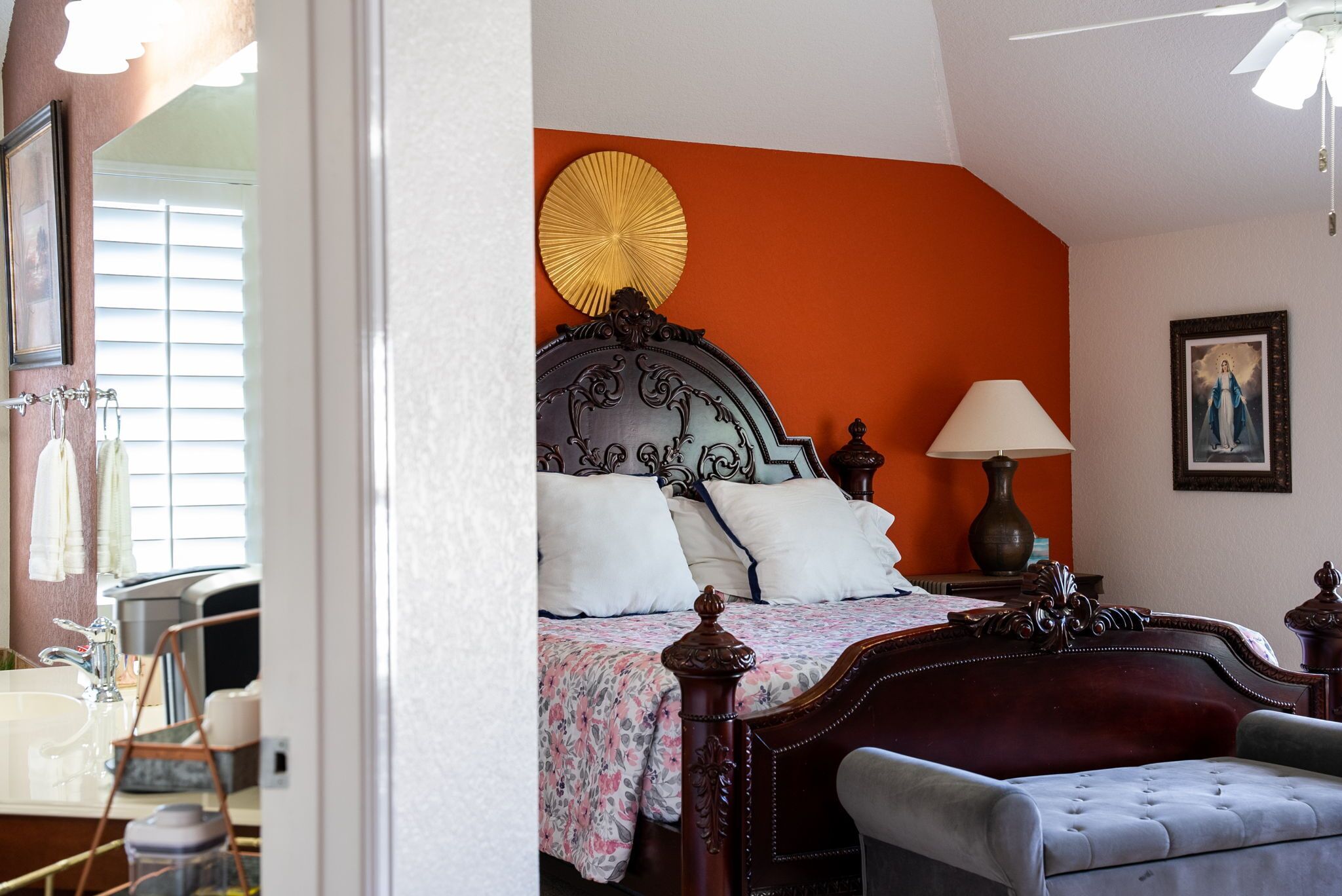 A bedroom with a large bed, a bedside table with a lamp, and a framed picture on the wall.