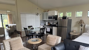 A modern hotel room with a dining area, kitchenette, and seating with patterned upholstery. - Large luxury studio with view in of golf course , (Santa Monica)