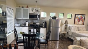 A modern kitchen with a dining area, a refrigerator, and a sofa. - Large luxury studio with view in of golf course , (Santa Monica)