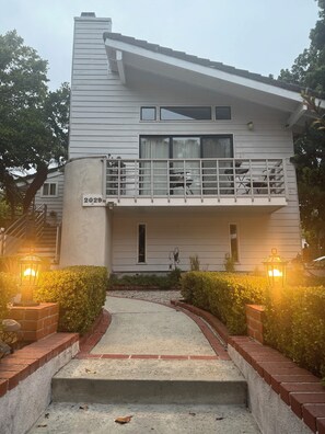 A two-story house with a balcony, a front entrance with steps, and a mailbox. - Large luxury studio with view in of golf course , (Santa Monica)