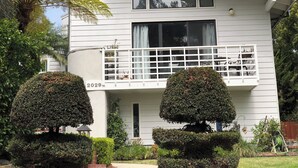 A two-story house with a balcony, a small porch, and a number '2029' on the front wall. - Large luxury studio with view in of golf course , (Santa Monica)
