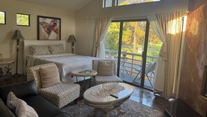 A bedroom with a bed, two bedside tables, a sofa, a coffee table, and a balcony with a view of the outdoors. - Large luxury studio with view in of golf course , (Santa Monica)