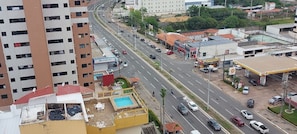 A multi-story building with a rooftop pool and a yellow structure with a red roof. - Flat Number One Ferreira Hospdagens (São Luís)