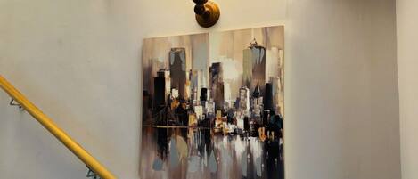 A painting of a cityscape on a wall.