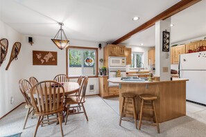 Enjoy meals in the kitchen with a central island and bar stools, a dining area with a table and chairs, and a comfortable rug.