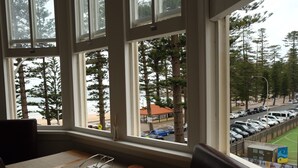 A room with a large window overlooking a parking area and a road with cars. - World famous beach location Manly (Sydney)