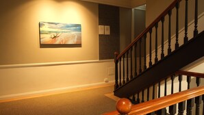 A staircase with wooden balusters and a handrail, carpeted floor, and a painting on the wall. - World famous beach location Manly (Sydney)