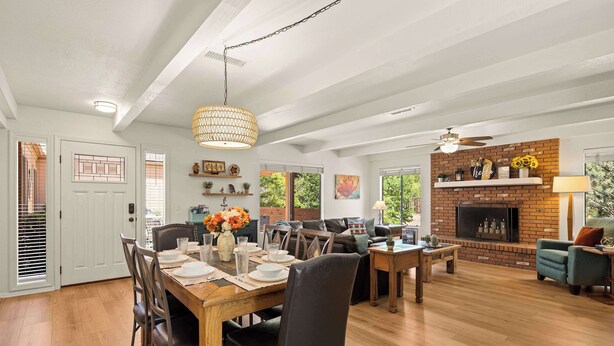 A spacious living area with a fireplace, dining table, and seating.