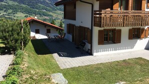 A chalet with a balcony overlooking a mountainous landscape.