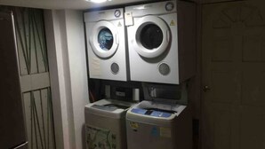 A laundry room with two front-loading washing machines and two dryers.