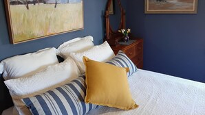 A bedroom with a bed, pillows, a dresser, a mirror, and two paintings on the wall. - Cullalo ArtHouse- gorgeous accommodation combined with an art gallery! - Stunning one bedroom apartment in east Albury (East Albury)